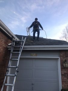 Cesar is tied off cleaning gutters. A great gutter cleaner